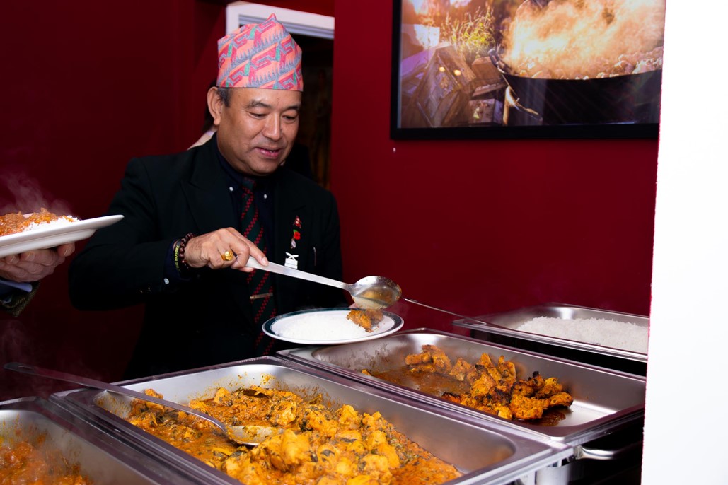 article thumb - Man plating up a Nepali curry